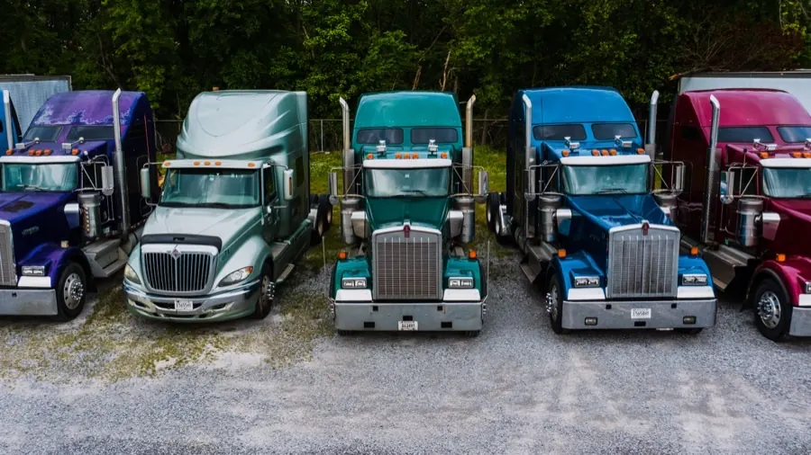Line of semi tractors at a trucking yard.